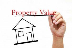 Property Value - House with text and male hand with pen